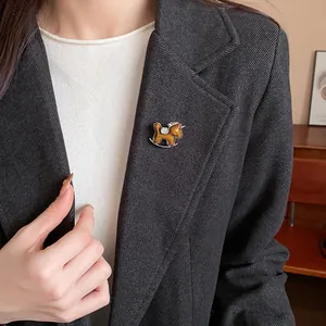 Detail shot of an elegant rhinestone resin rocking horse brooch on a black blazer