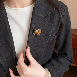 Close-up of an elegant resin rocking horse brooch with diamond inlay on a black blazer
