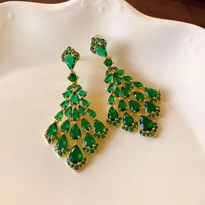 Dettaglio macro di orecchini pendenti vintage con zirconi color verde smeraldo
