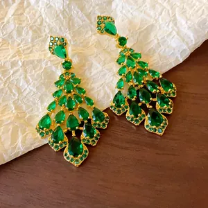 Primo piano di orecchini a pendente lungo in zircone verde smeraldo a forma di foglia