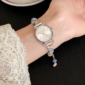 Close-up detail of women's vintage watch featuring ceramic beads and woven wax cord strap