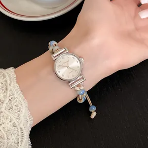 Close-up of a vintage-style quartz watch with blue ceramic beads and woven cord strap