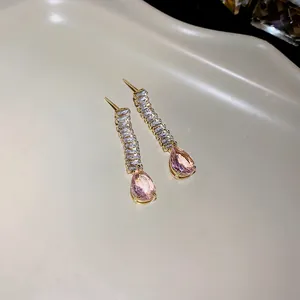 Vue détaillée de boucles d'oreilles élégantes plaquées or avec cristaux de larme rose