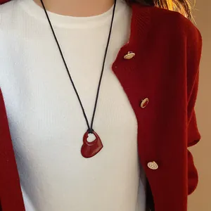 Gros plan d'un collier minimaliste avec pendentif cœur rouge pour femmes