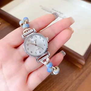 Close-up detail of a chic women's watch with ceramic beads and woven wax cord strap