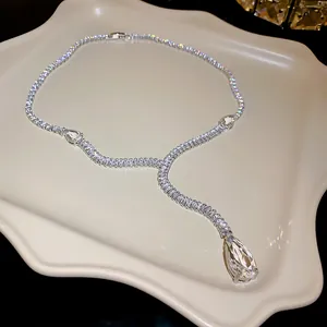 Détail d'un collier en Y argenté avec un grand pendentif en forme de goutte en zircone cubique.