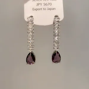Vue rapprochée de boucles d'oreilles de luxe avec zircon et gouttes violettes