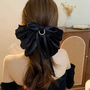 Detailansicht einer Frau mit großer schwarzer Samtschleife und Strass-Haarspange