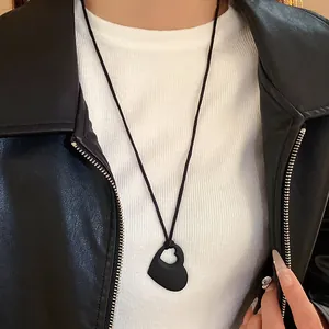 Collier élégant avec pendentif cœur ajouré noir sur mannequin avec veste en cuir