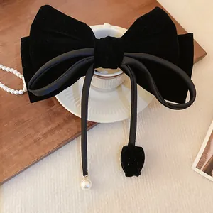 Detailansicht einer eleganten schwarzen Samt-Schleife-Haarspange mit Perlenanhänger