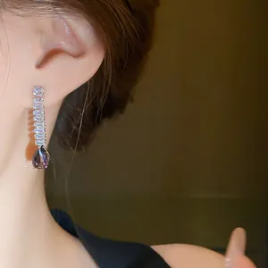 Vue détaillée d'une élégante boucle d'oreille argentée avec un cristal goutte violet