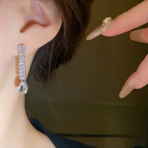 Gros plan d'élégantes boucles d'oreilles goutte en zircone montrant les détails des pierres.