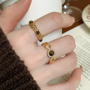 Detailed close-up of vintage gold-plated rings featuring tiger eye stones and pavé accents