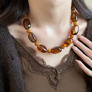 Vintage Maillard brown acrylic necklace with irregular chunky beads showing wearing detail
