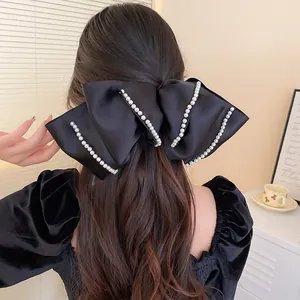 Elegante große schwarze Satin-Schleife-Haarspange mit weißen Perlen für langes Haar