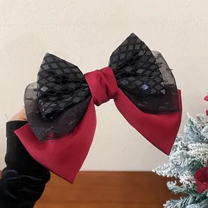 Detailansicht einer großen rot-schwarzen Schleifen-Haarklammer mit glitzernden Pailletten.