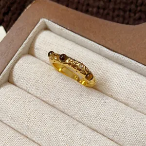 Close-up detail of vintage gold plated ring with tiger eye stones and hammered texture