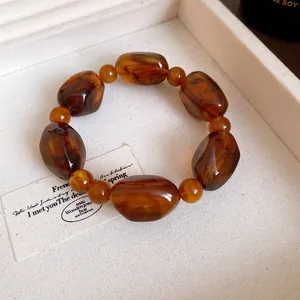 Close-up of vintage Maillard style amber acrylic beaded bracelet in jewelry tray