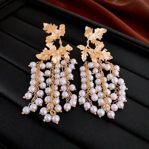 Detailed macro shot of vintage gold leaf earrings featuring elegant cascading pearl tassels