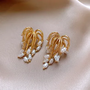 Close-up detail showing the intricate gold texture and pearls of vintage floral earrings