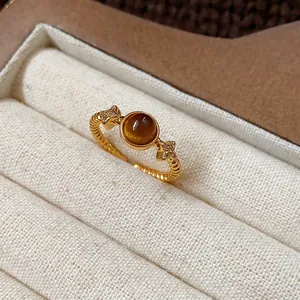 Macro view of a gold plated tiger eye open ring with shimmering star accents in a box.