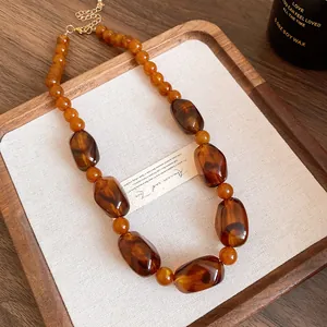 Detailed view of retro Maillard style acrylic beaded necklace with amber tones