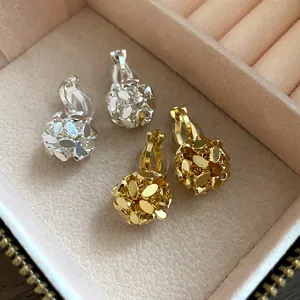 Detailed macro view of 18k gold plated flower cluster clip-on earrings in jewelry box