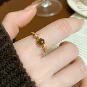 Macro detail of a gold-plated vintage ring featuring a brown tiger eye stone and stars