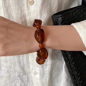 Close-up of retro Maillard style amber acrylic irregular beaded bracelet on wrist