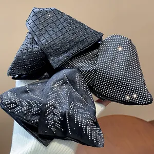 Close-up detail of large black fabric shark clips with elegant rhinestone patterns