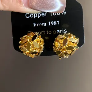 Close-up of vintage 18k gold plated floral cluster ear clips on black display card