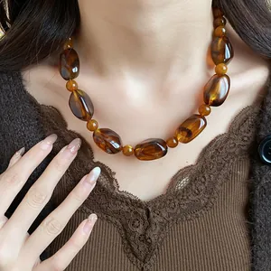 Close-up of vintage amber acrylic beaded necklace on model