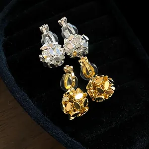 Detailed view of 18k gold plated flower cluster ear clips in gold and silver finish