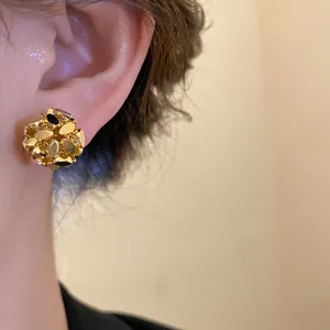 Close-up view showing the textured detail of a vintage 18k gold-plated flower cluster ear clip