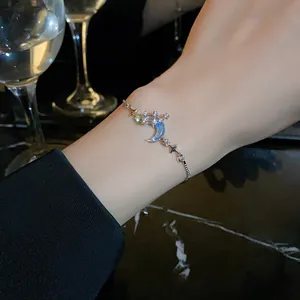 Exquisite silver bracelet with zircon crescent moon and star charms worn on a wrist