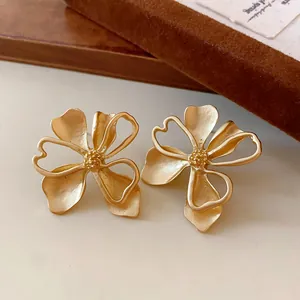 Vista de detalle de pendientes de flores vintage en oro mate con pétalos de corazón