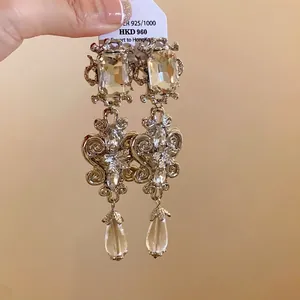 Elegant vintage-style silver drop earrings with square crystals and teardrop pendants.