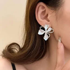 Primer plano detallado de pendientes de flores plateados retro con un acabado mate