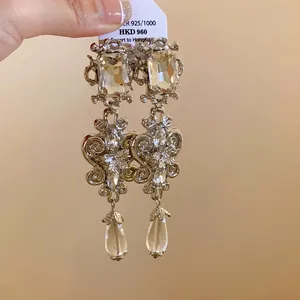 Detailed view of ornate silver-tone long drop earrings with clear faceted crystal accents