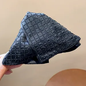 Macro view showing the intricate black beaded grid pattern on the triangle fabric hair clip