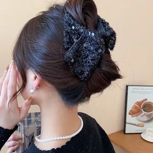 Large black sequined bow hair claw clip shown worn on hair for a stylish Korean aesthetic