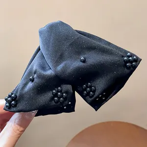 Close-up of black fabric triangular hair claw clip with elegant black bead clusters.