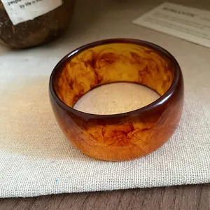 Detailed macro view showing the artistic textures of the amber marbled resin bangle