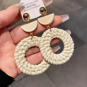 Vue détaillée des boucles d'oreilles pendantes en raphia avec clous en argent 925.