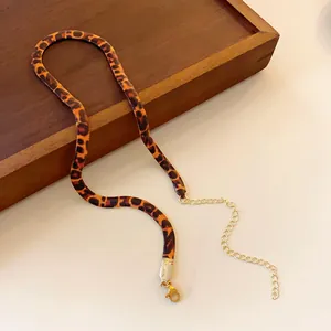 Close-up of a stylish leopard print snake chain necklace with gold clasp and extender
