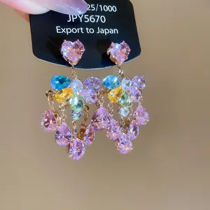 Macro view of crystal flower earrings with colorful zircon drops on gold plating.