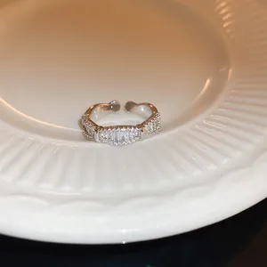 Primo piano di un elegante anello aperto in argento con zirconi incastonati su un piatto