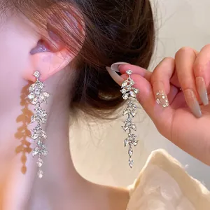 Detailed view of sparkling silver leaf tassel earrings with brilliant rhinestones.