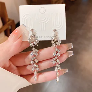 Close-up of sparkling silver leaf-shaped tassel earrings with zirconia crystals