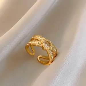 Vista dettagliata di un elegante anello di perle dorate con cuore in zircone su seta crema